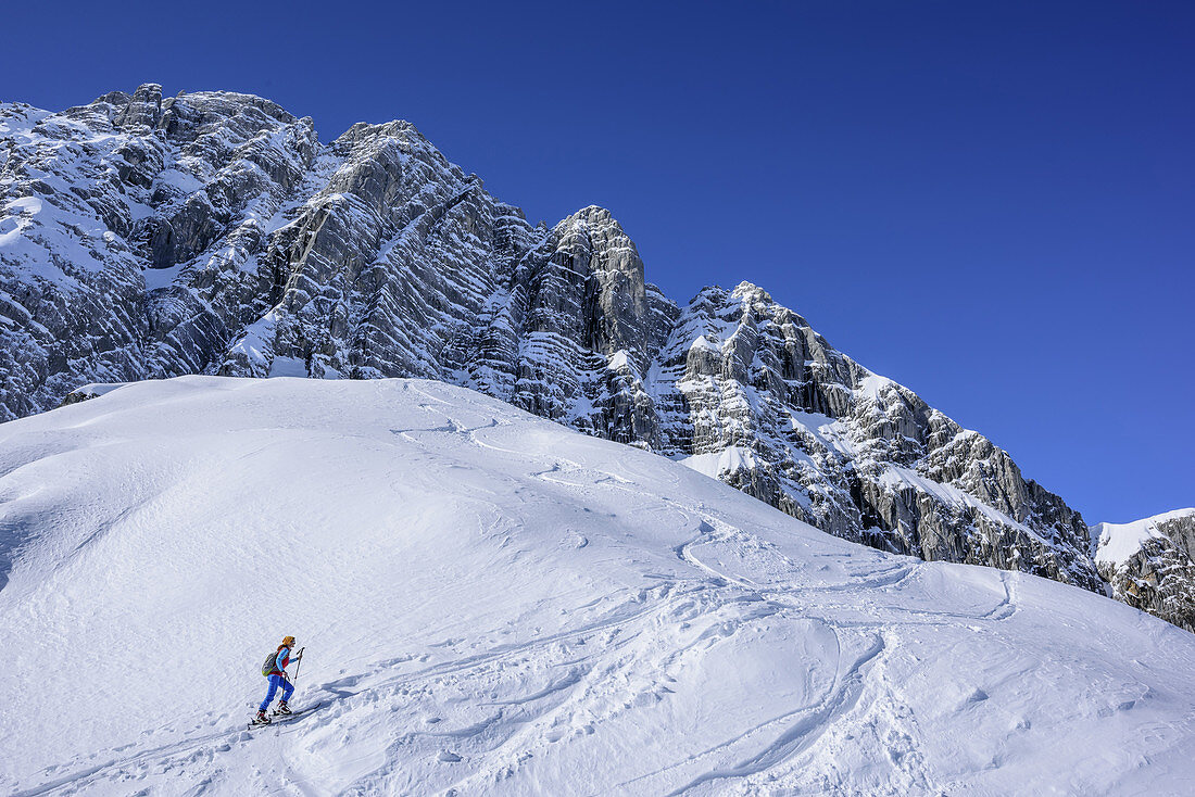 Frau auf Skitour steigt zur Hochalm auf, Blaueisspitze im Hintergrund, Hochalm, Hochkalter, Nationalpark Berchtesgaden, Berchtesgadener Alpen, Berchtesgaden, Oberbayern, Bayern, Deutschland