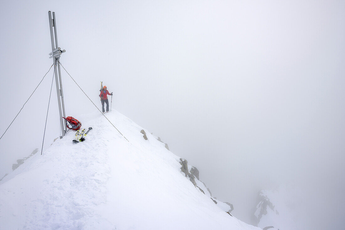 Frau auf Skitour steigt durch Nebel zum Gipfel der Cima d' Asta, Cima d' Asta, Fleimstaler Alpen, Dolomiten, UNESCO Weltnaturerbe Dolomiten, Trentino, Italien