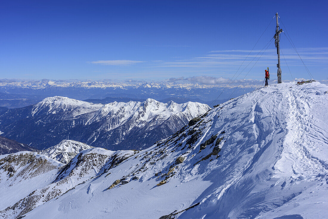 Woman back-country skiing standing at summit of Hasenoehrl, Hasenoehrl, valley of Ultental, Ortler Range, South Tyrol, Italy