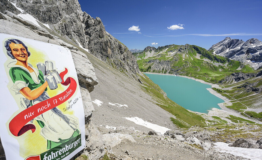 Sign with beer advertisement and lake Luenersee in background, lake Luenersee, Raetikon trail, Raetikon, Vorarlberg, Austria