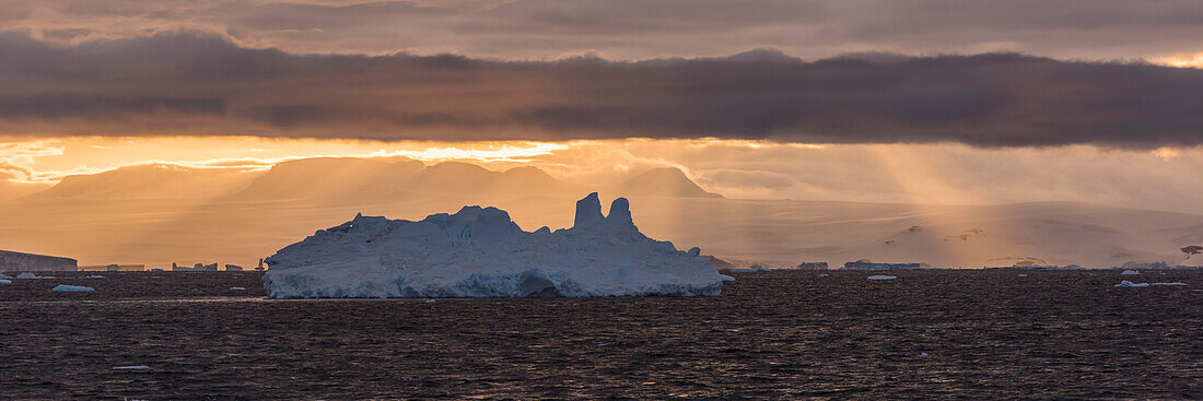 'Jagged iceberg in silhouette against dawn sky; Antarctica'
