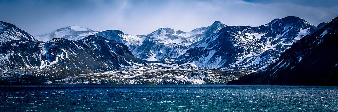 'Snowy mountains in sunshine beside blue sea; Antarctica'