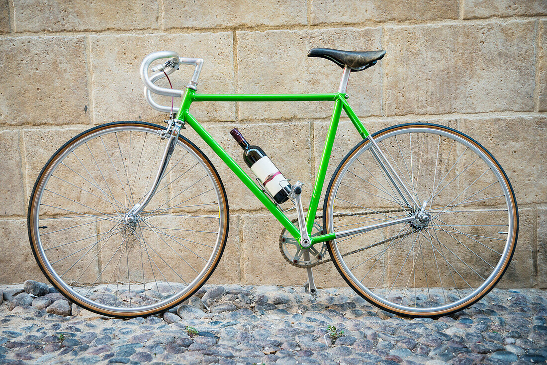 'Green bicycle with bottle of wine; Alghero, Sardinia, Italy'