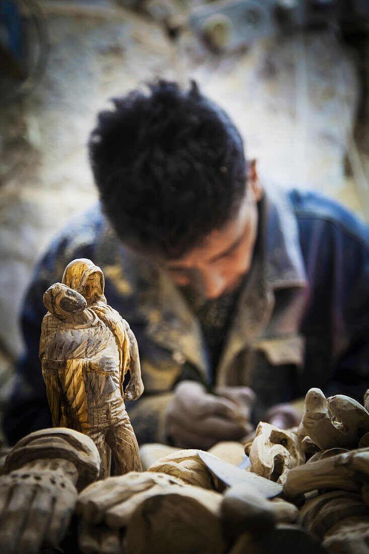 'A man hand carves figurines; Bethlehem, Jerusalem'