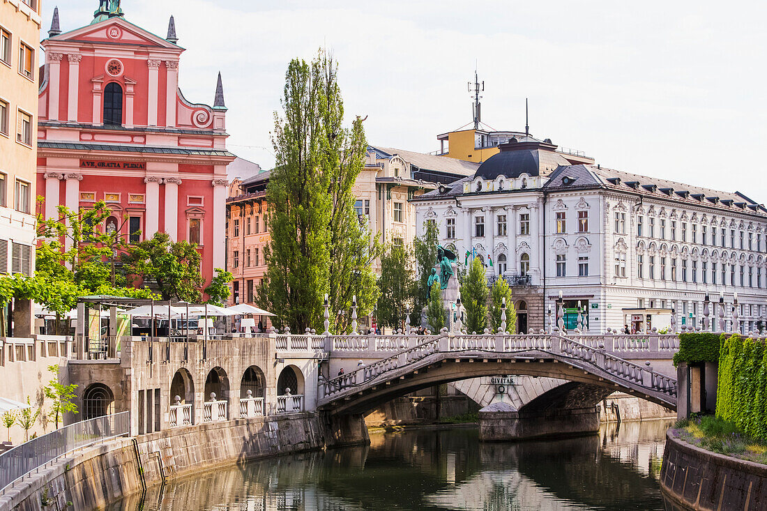 'The Slovenian capital city of Ljubljana, with a footbridge over a tranquil canal; Ljubljana, Slovenia'