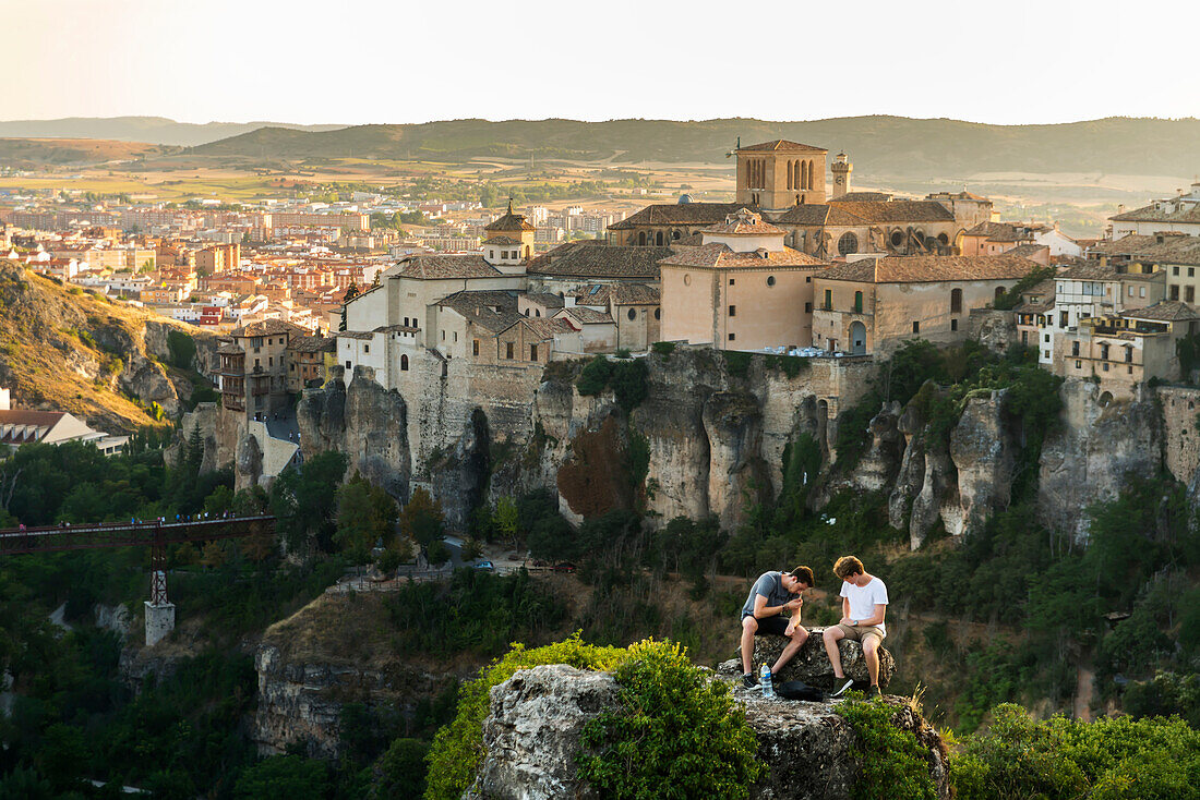 'Two friends having rest in the surroundings of Cuenca with a beautiful landscape behind them; Cuenca, Castile-La Mancha, Spain'