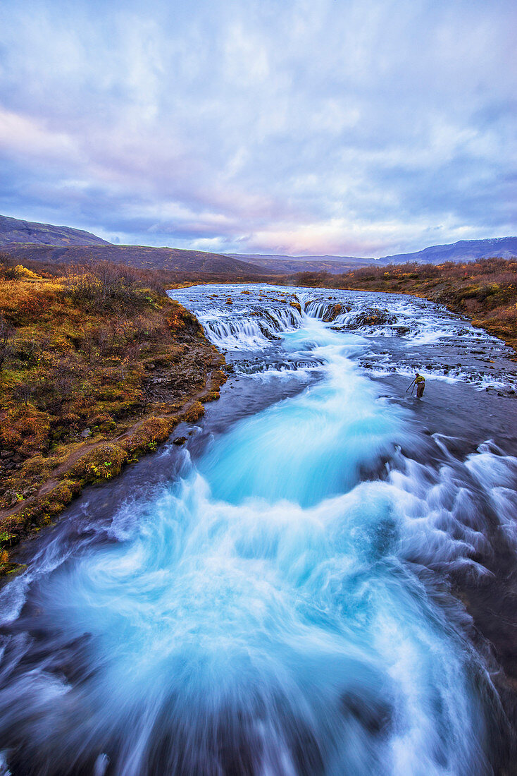 'Person photographing the waterfall Bruarfoss; Iceland'