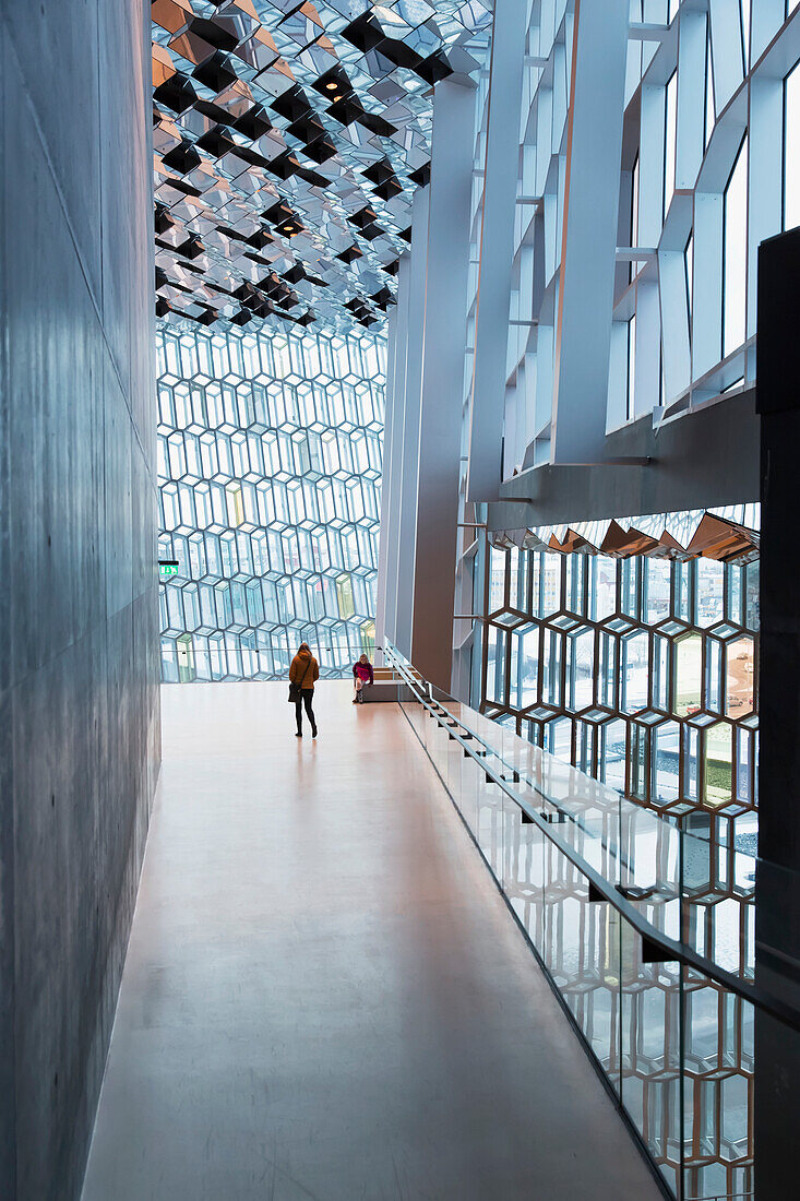 'Mother and daughter explore interior of the Harpa public concert hall, designed by the Danish firm Henning Larsen Architects and the Icelandic firm Batteriao Architects, the glass facade designed by Icelandic glass artist Olafur Eliasson; Reykjavik, Icel