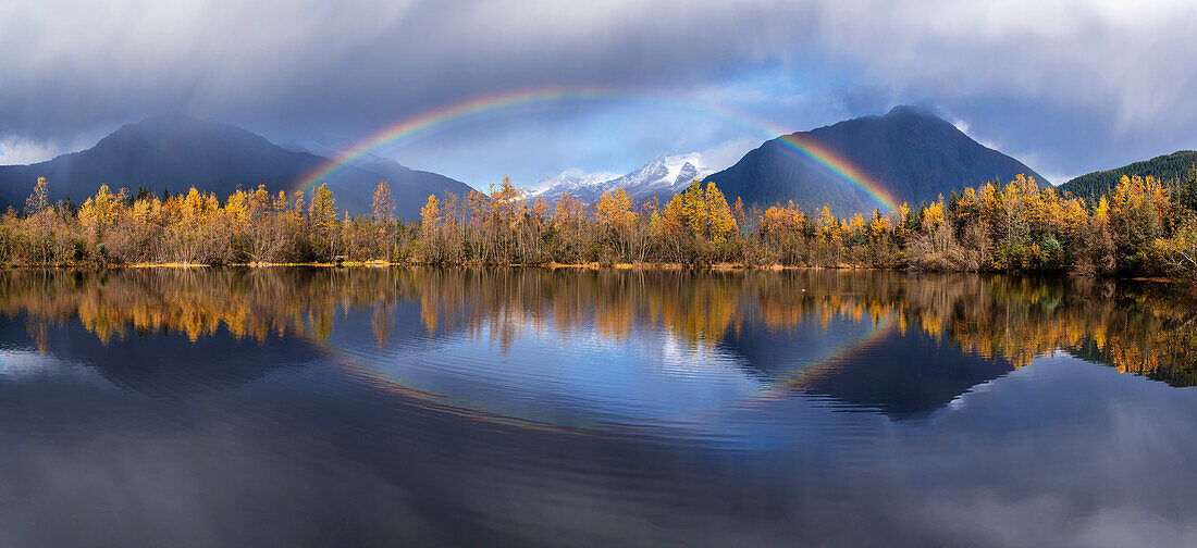 Scenic view of autumn rain showers and a rainbow reflected in Moose Lake, Mendenhall Recreation Area, Tongass National Forest, Juneau, Southeast Alaska