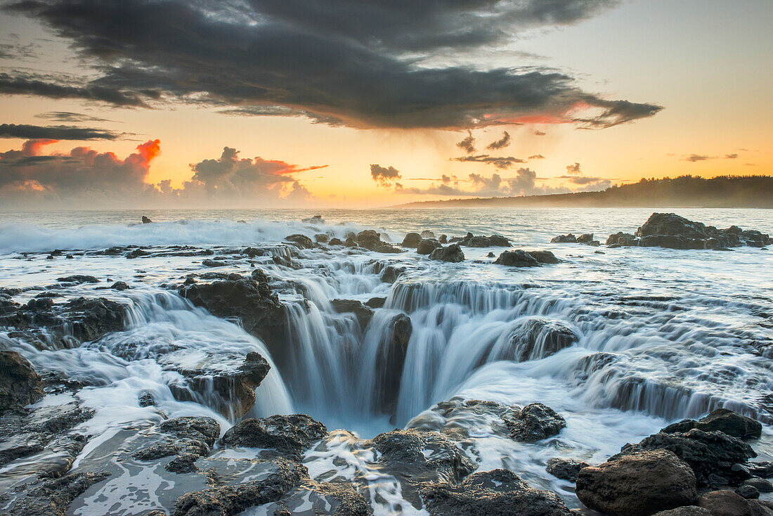 'Surf spills into a hole in a rock outcrop on the east side of Kauai; Kauai, Hawaii, United States of America'