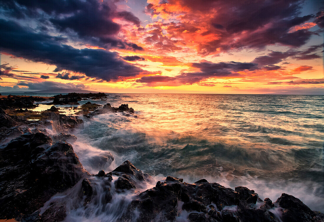 'Dramatic colourful sky at sunset over the pacific ocean and the rugged coastline of a hawaiian island; Hawaii, United States of America'