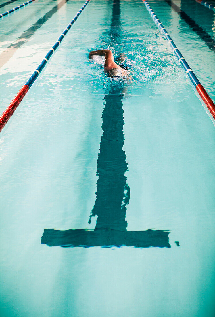 Man Swimming in Indoor Swimming Pool