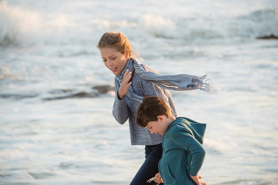 Happy mother and son walking on the beach