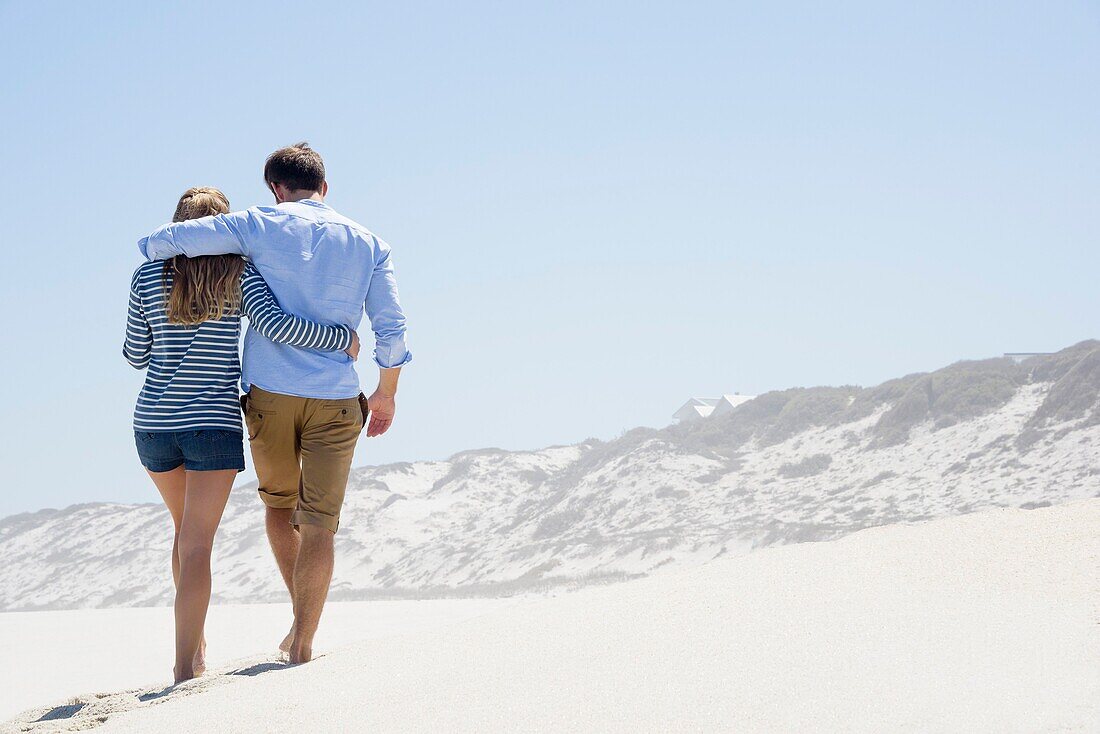 Rear view of a couple walking on the beach