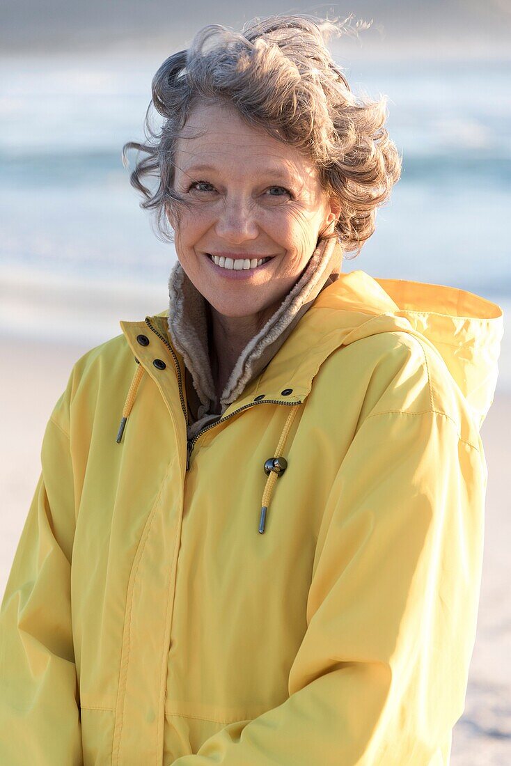 Portrait of happy mature woman smiling on the beach