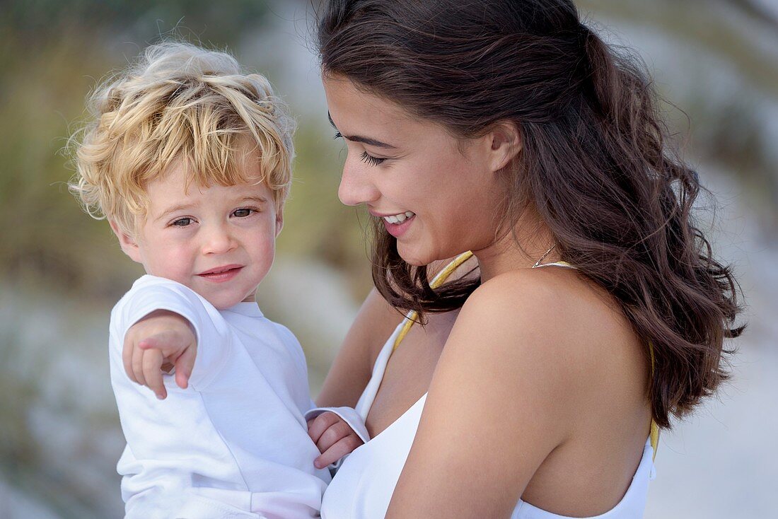 Happy mother with her little son enjoying on beach