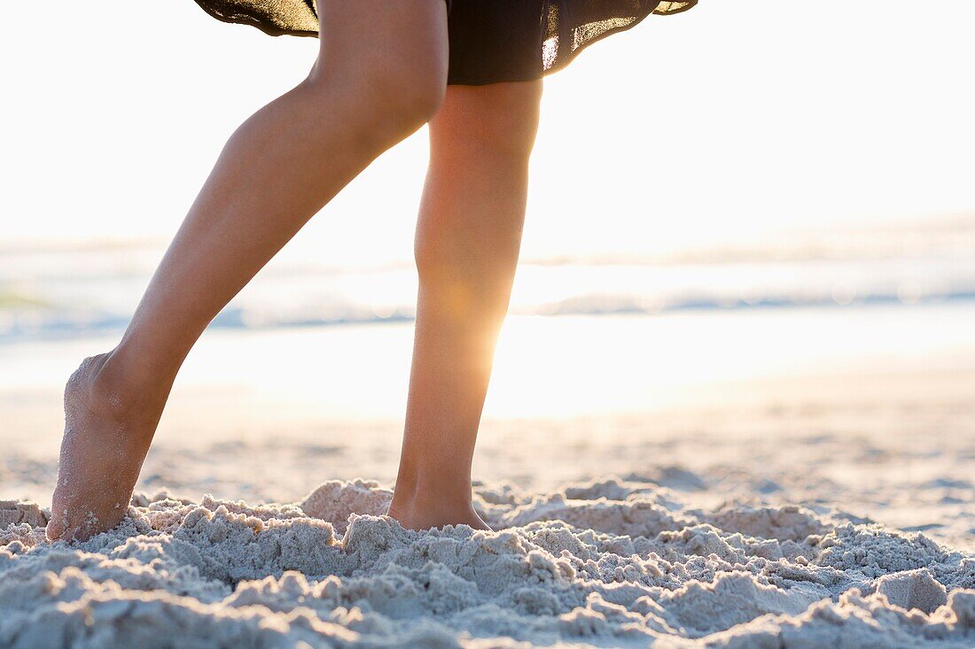 Low section view of woman walking on the beach