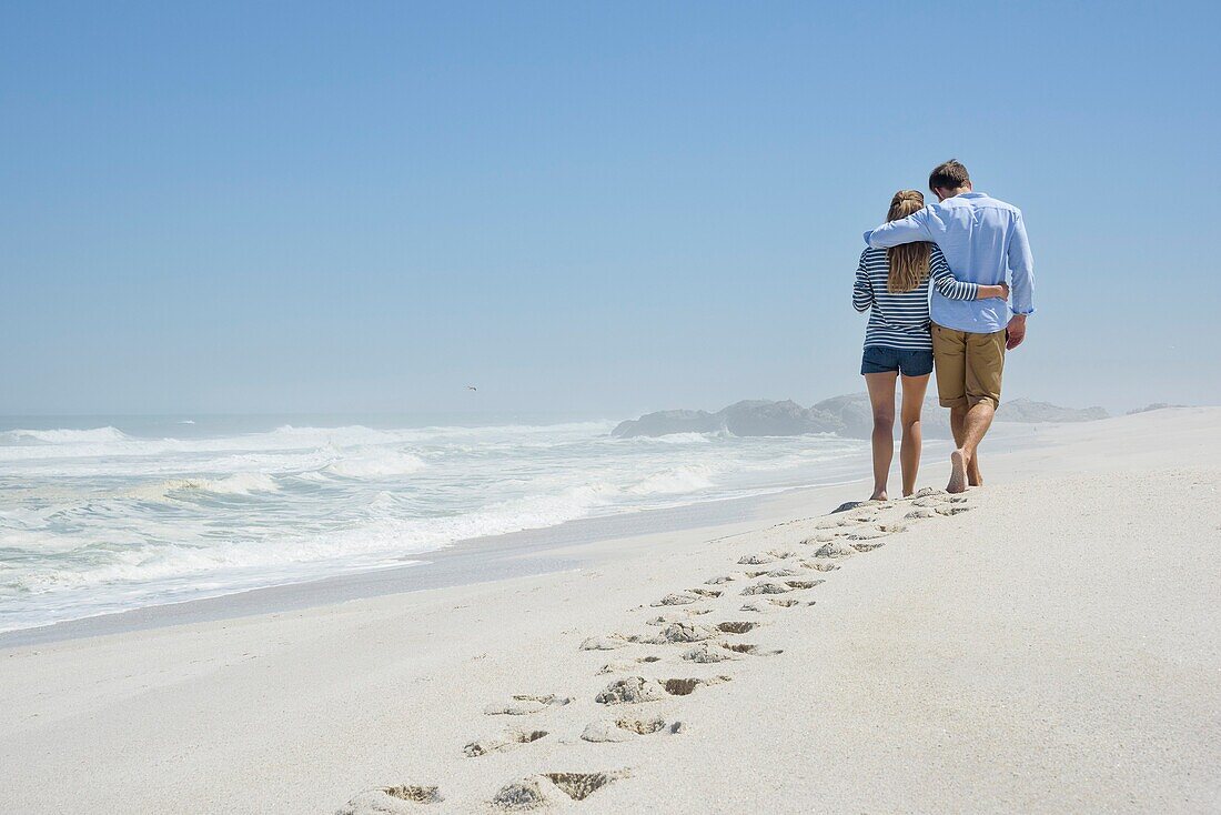 Rear view of a couple walking on the beach