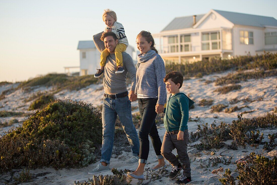 Couple with their two children walking on the beach