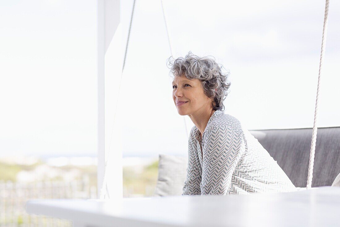 Woman sitting on a swing and day dreaming