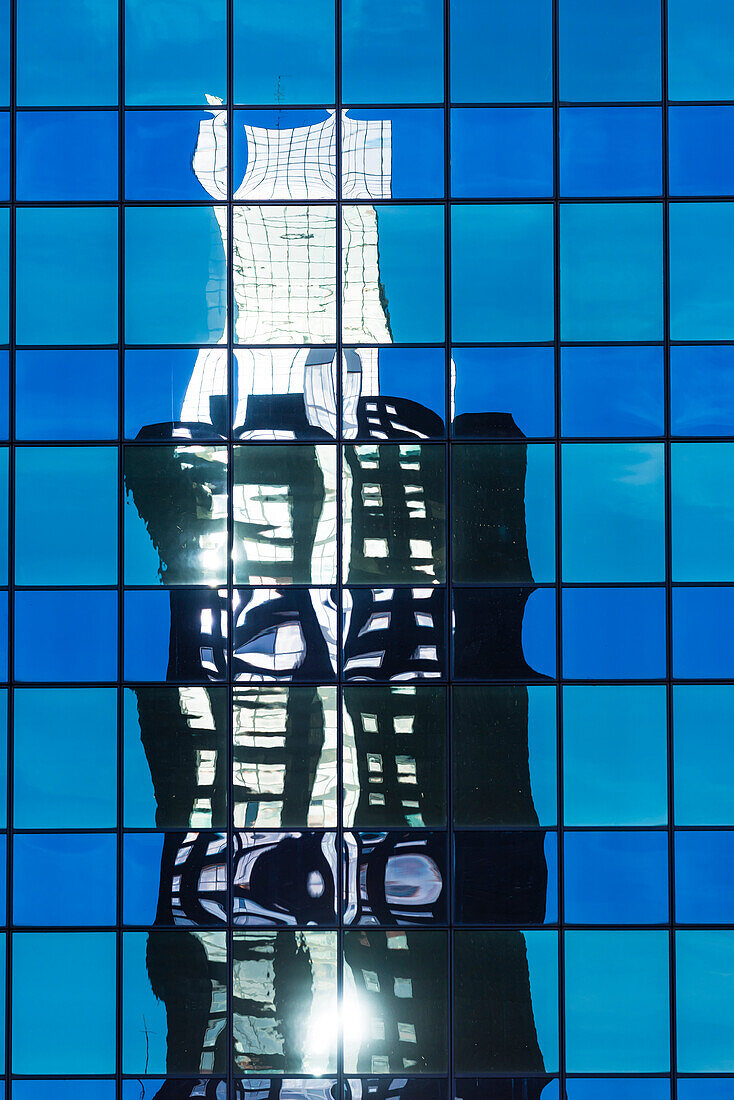 A high-rise office block reflected in the glass facade of another high rise building in the city centre, Rotterdam, Netherlands