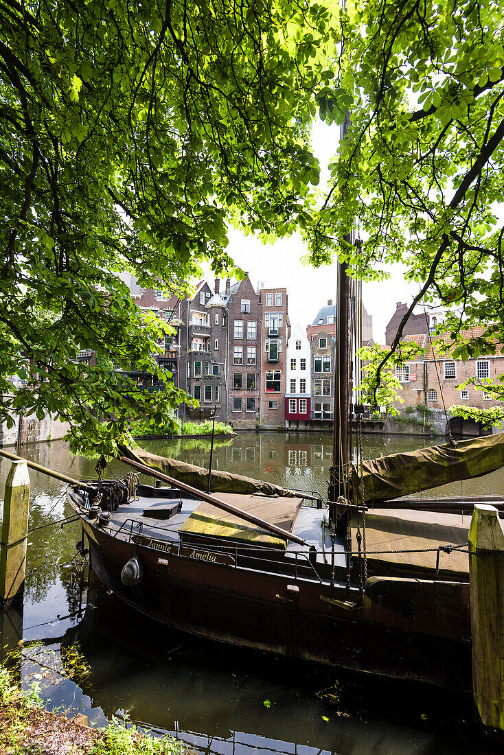 Old sailing ships on Aelbrechtskolk canal in front of the scenery of historical houses in Delfshaven, Rotterdam, Netherlands