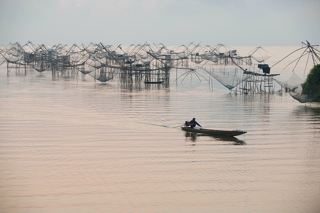 Shore-operated lift net, fishermen on boat at sunrise, Phatthalung, Thailand
