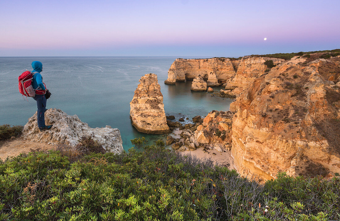The photographer admires cliffs and ocean of Praia da Marinha at dawn, Caramujeira, Lagoa Municipality, Algarve, Portugal, Europe