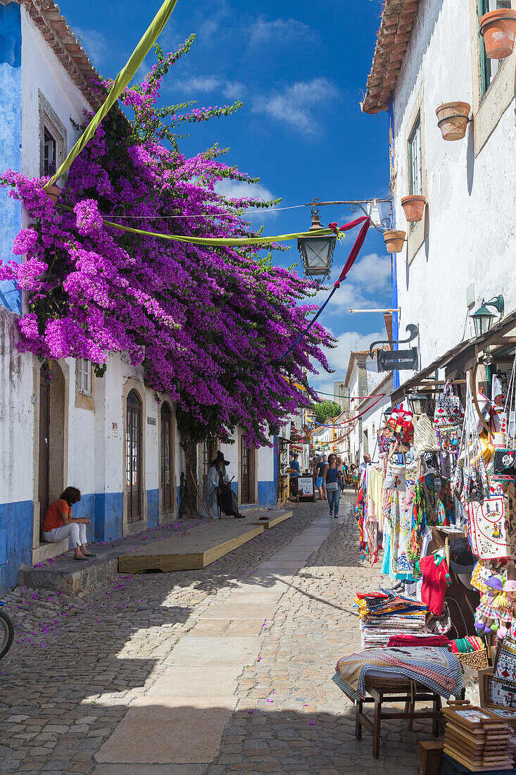 Tourists and shops in the typical alleys of the ancient fortified village of Obidos, Oeste Leiria District, Portugal, Europe