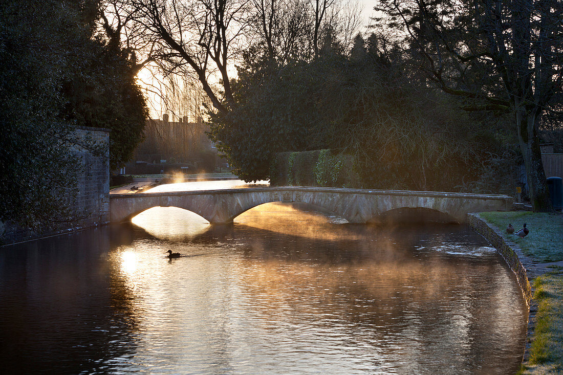 Cotswold stone bridge over River Windrush in mist, Bourton-on-the-Water, Cotswolds, Gloucestershire, England, United Kingdom, Europe