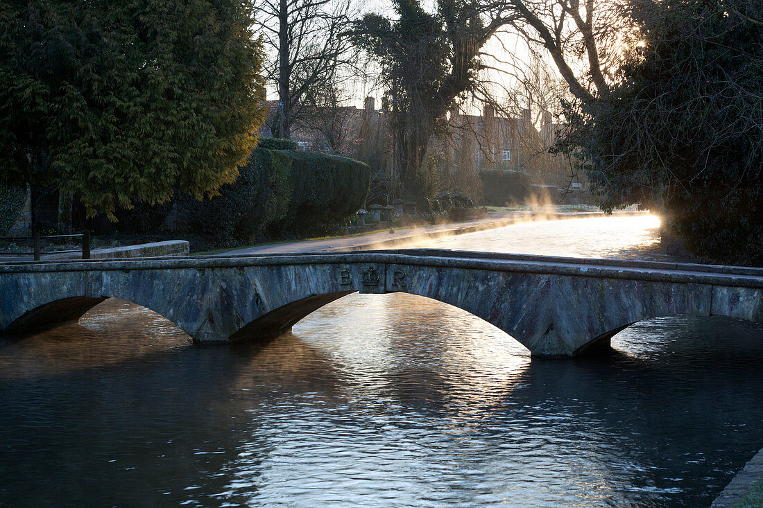 Cotswold stone bridge over River Windrush in mist, Bourton-on-the-Water, Cotswolds, Gloucestershire, England, United Kingdom, Europe