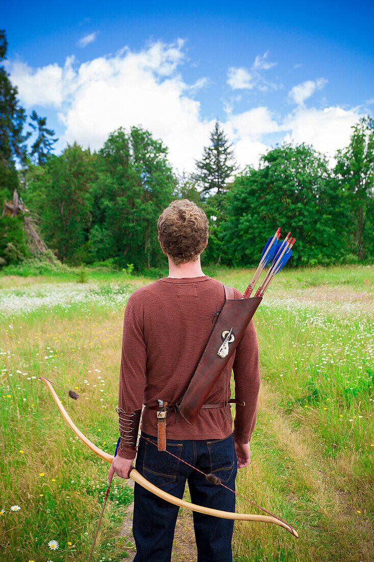 Young adult male with archery gear outdoors This high school senior portrait shows the archer enjoying his recreational sport