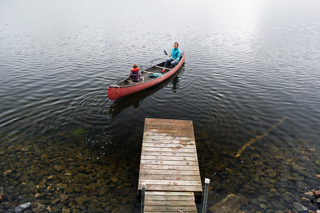 Mother and young son push away from dock at Kezar Lake