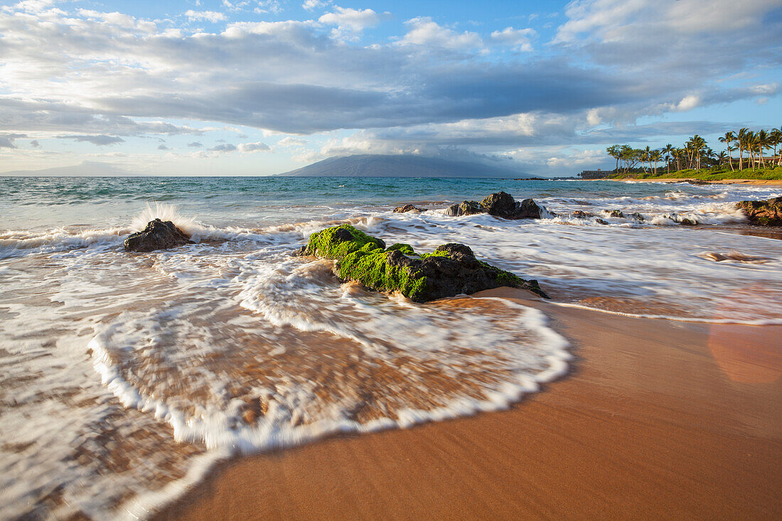 'Mokapu Beach at sunset with mossy lava rocks; Wailea, Maui, Hawaii, United States of America'