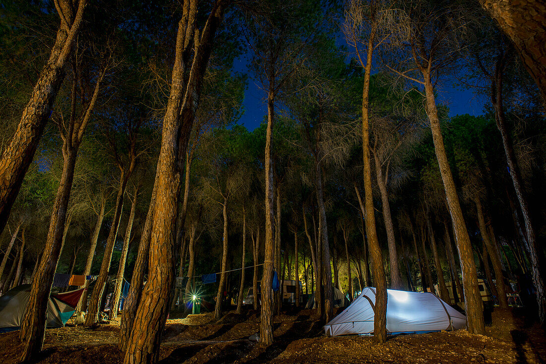 'A tent illuminated at dusk at a campground; Cala Gonone, Sardinia, Italy'
