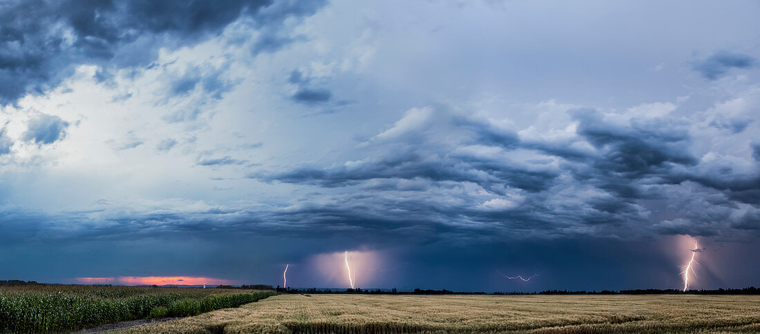 'Storm clouds and lightning strikes over a rural landscape; Thunder Bay, Ontario, Canada'
