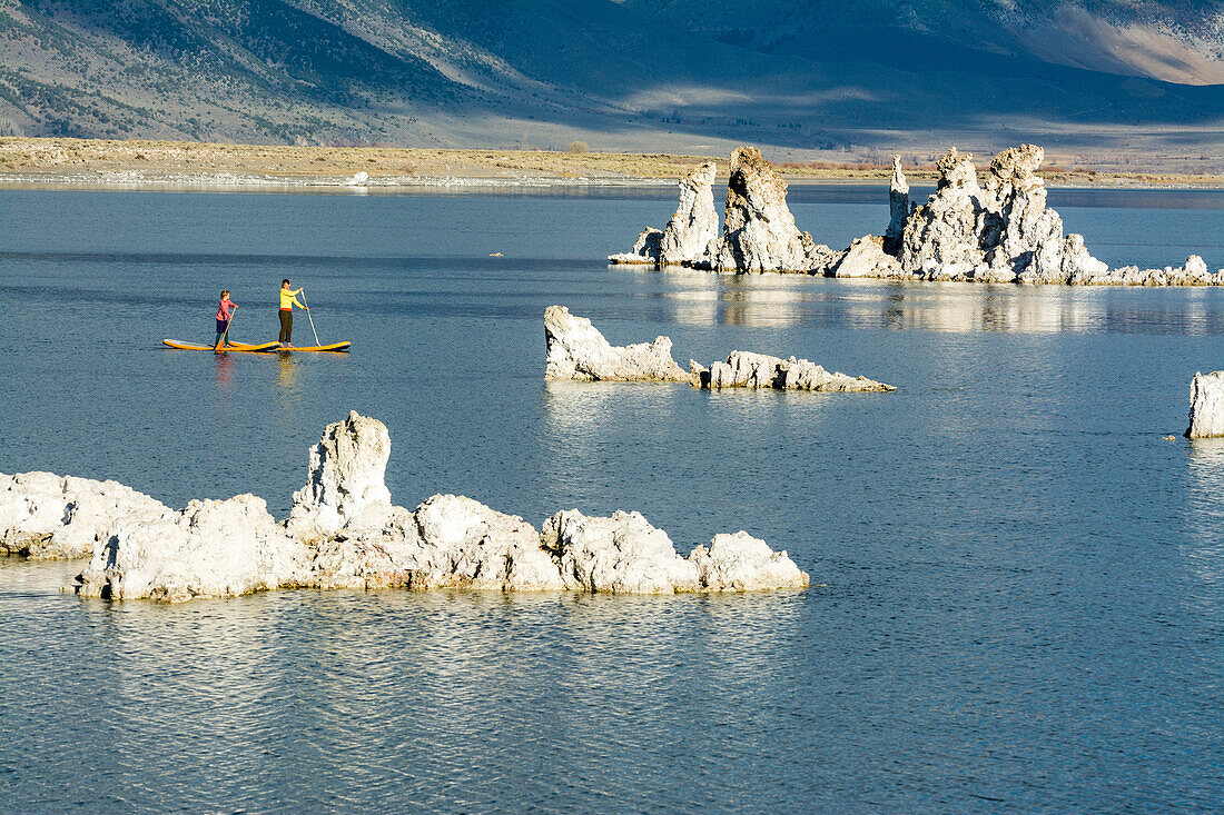 A woman and her daughter stand up paddleboarding on Mono Lake from South Tufa Beach, Lee Vining, California.
