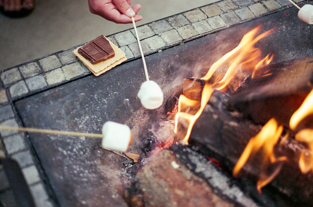 Marshmallows roast over a backyard fire pit