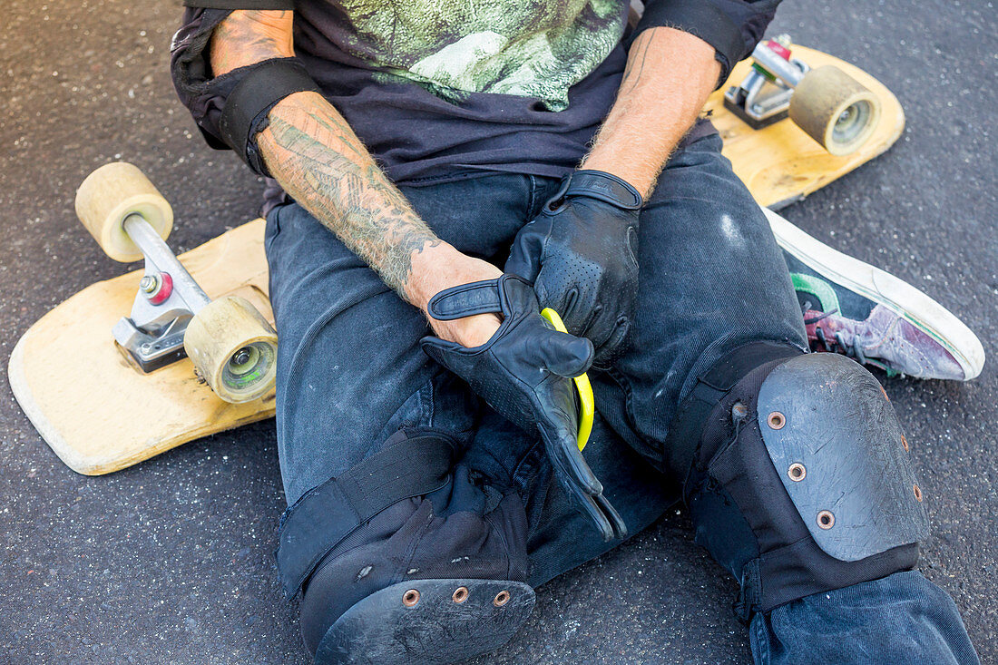 Close up of skateboarder hands with sloves and board