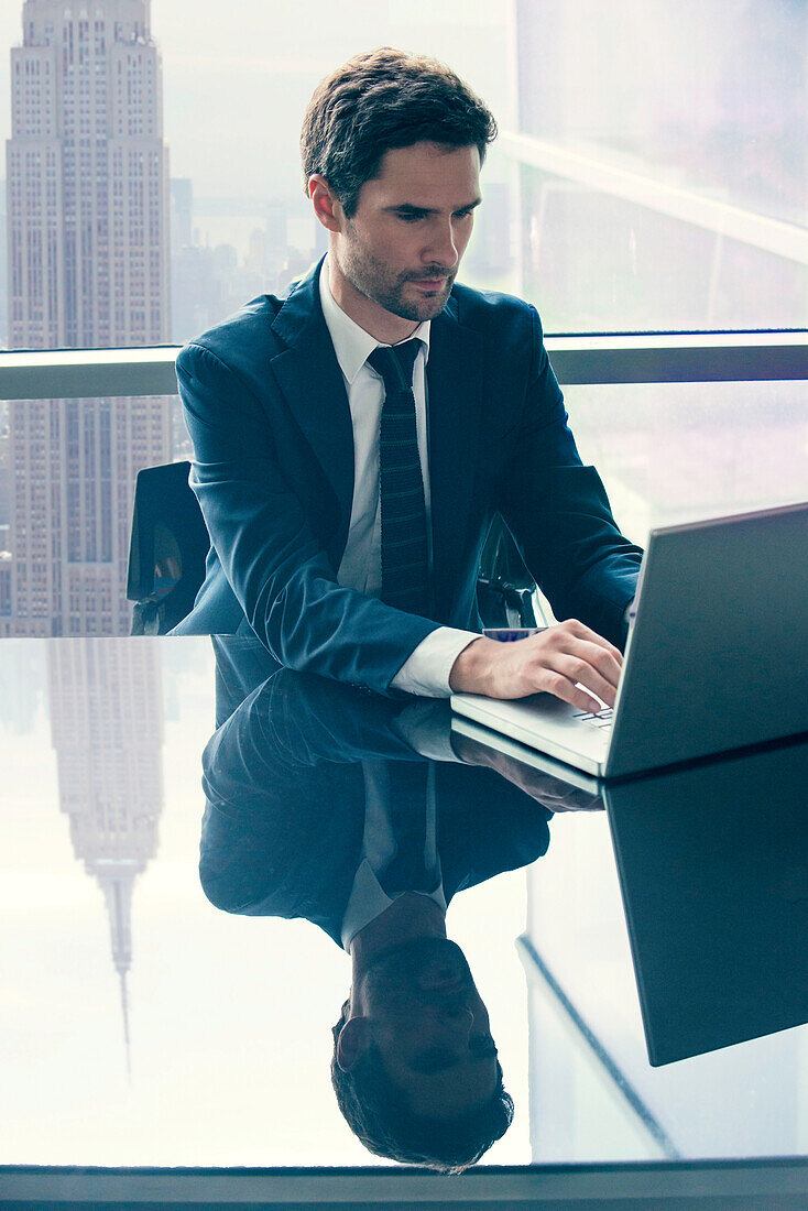 Businessman using laptop computer alone at conference table