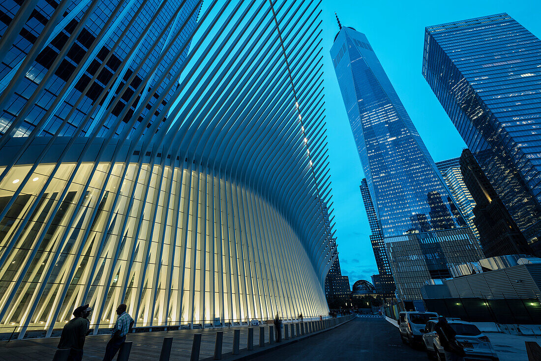the Oculus and One World Trade Center exterior during dusk, futuristic train station by famous architect Santiago Calatrava next to WTC Memorial, Manhattan, New York City, USA, United States of America