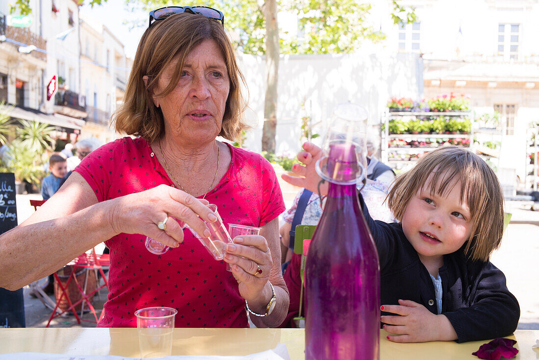 Woman and girl sitting at a table,  Mauguio,  Montpellier,  Hérault,  France