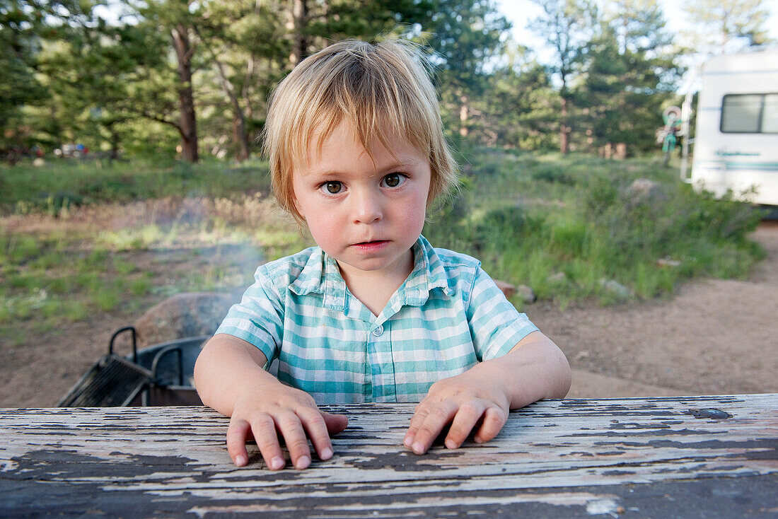 Little boy sitting at picnic table