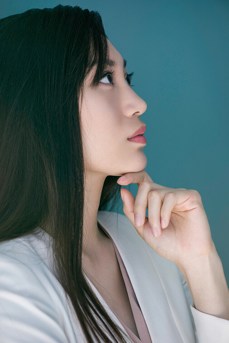 Woman daydreaming with hand under chin