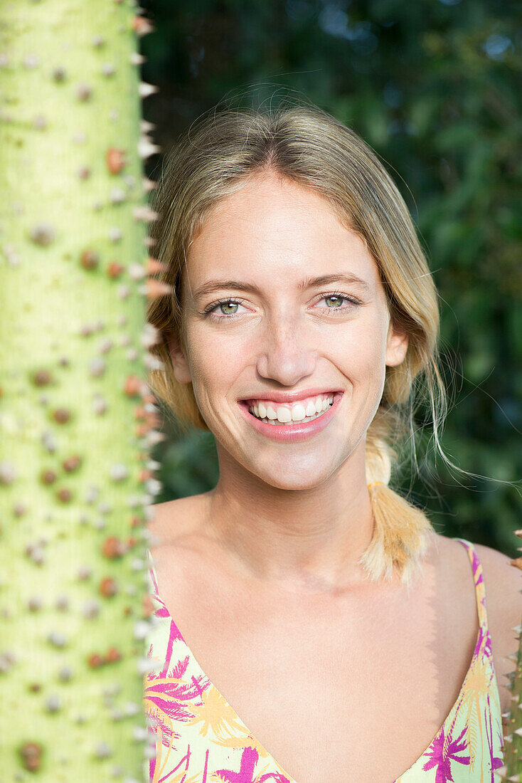 Young woman smiling cheerfully outdoors, portrait