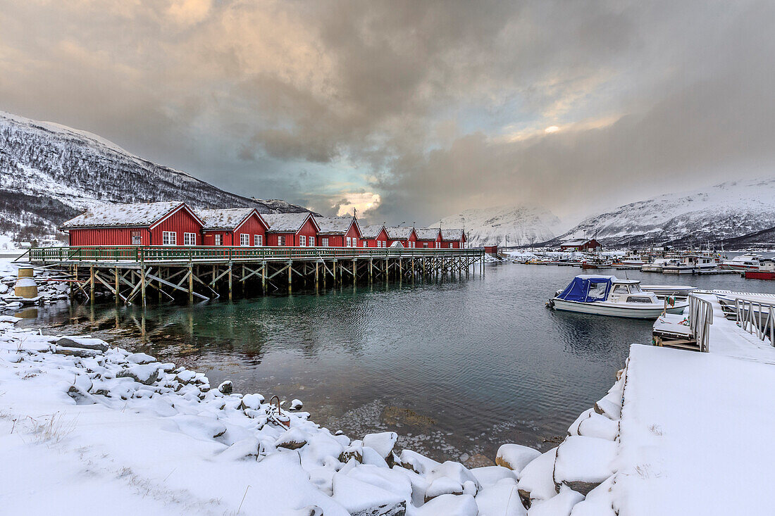 Typical red wooden huts of fishermen in the snowy and icy landscape of Lyngen Alps Troms?© Lapland Norway Europe