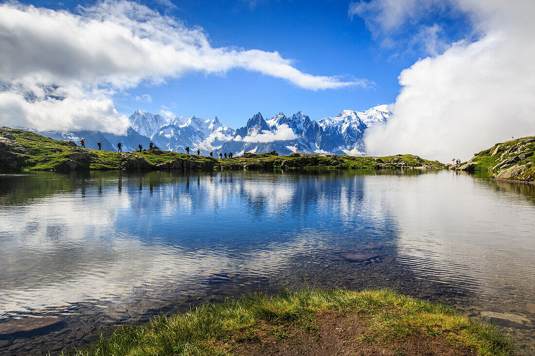 Low clouds and mist around Grandes Jorasses and Mount Blanc while hikers proceed on Lac De Cheserys Haute Savoie France Europe