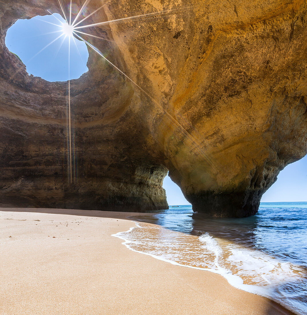 The sun shines through the natural rocky windows inside the caves of Benagil Faro District Algarve Portugal Europe
