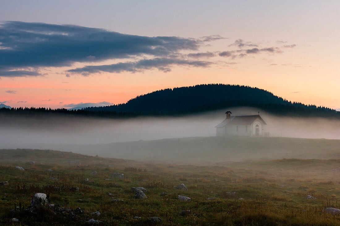 Chapel, Plains of Marcesina, Altopiano of Asiago, Province of Vicenza, Veneto, Italy. Saint Lorenzo church in the mist.