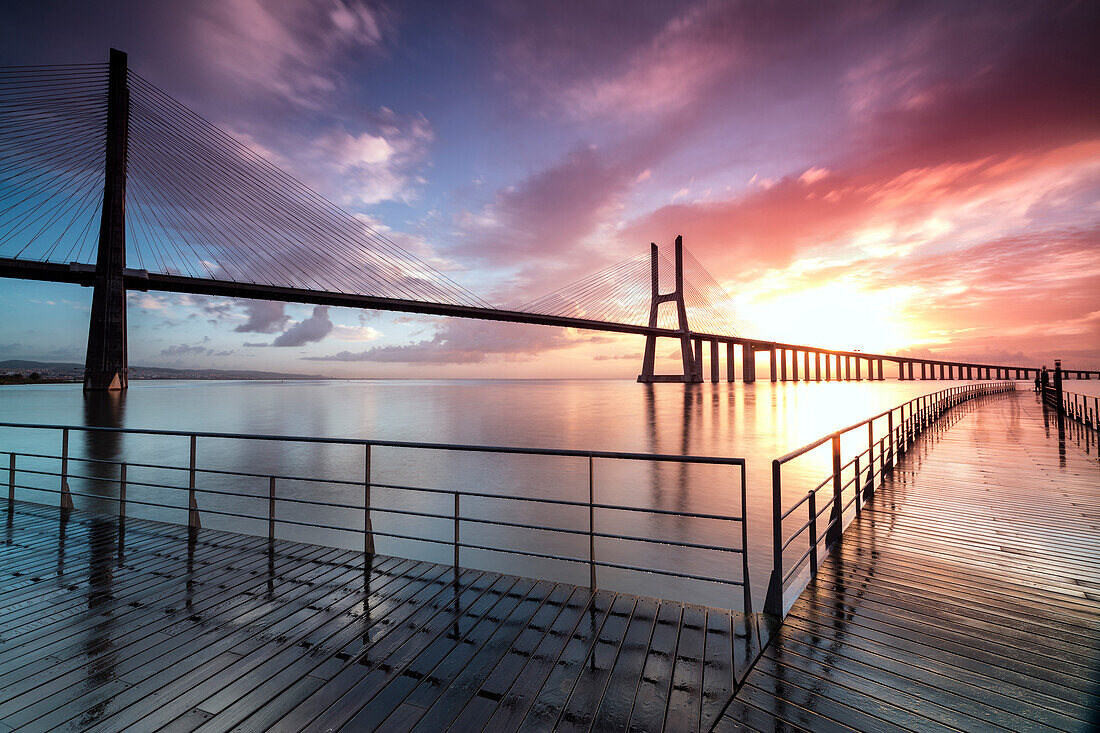 Perspective and architecture of Vasco Da Gama bridge enhanced by the colors of dawn Lisbon Portugal Europe